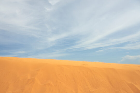 Sand dune in the desert with clouds in the background © Arthur