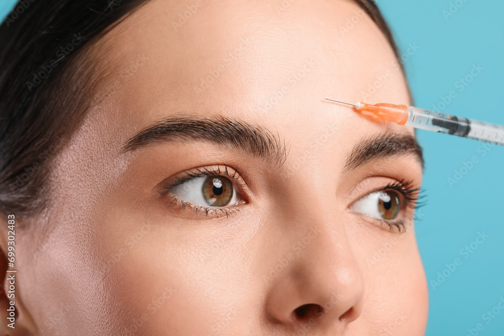 Canvas Prints Young woman getting facial injection on light blue background, closeup. Cosmetic surgery