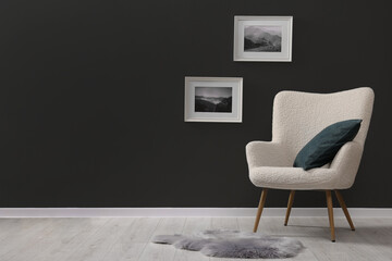 Stylish interior with comfortable armchair and rug on floor indoors, space for text