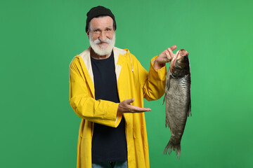 Fisherman with caught fish on green background