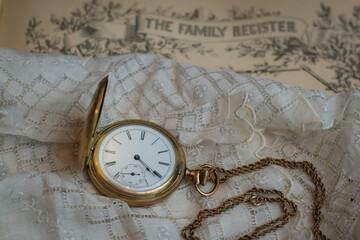 Sentimental photo of family items in times past with a family register, handkerchief and pocketwatch - obrazy, fototapety, plakaty