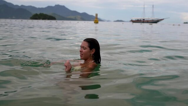 Brazilian young woman swim backstroke in the sea