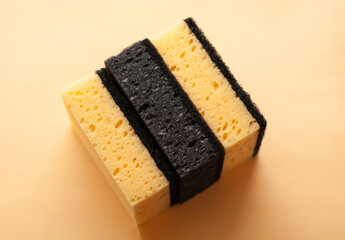 Cleaning sponges on a peach fuzz color background. Cleaning concept, cleaning service.Top view
