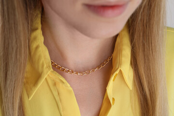 Closeup view of woman wearing metal chain. Luxury jewelry