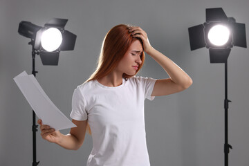 Casting call. Emotional woman with script performing on grey background