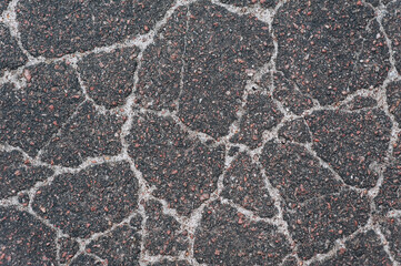 Background, texture, top view of wet asphalt with cracks on a street road. Photography, abstraction, pattern on the ground.
