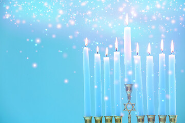Hanukkah celebration. Menorah with burning candles on light blue background, closeup. Space for text