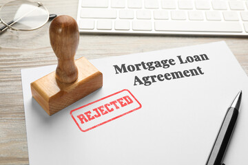 Mortgage loan agreement with Approved stamp and pen on table, closeup