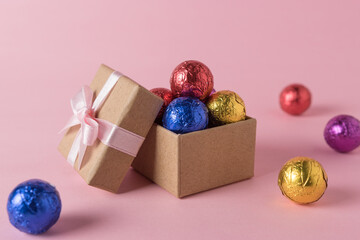 Creative layout of colored candy and gift box on pink background