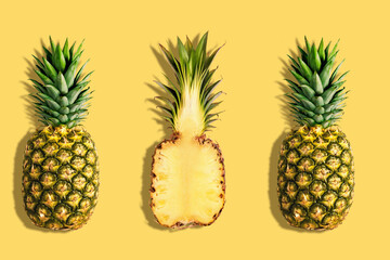 Fresh pineapples on yellow background. Creative suumer concept.