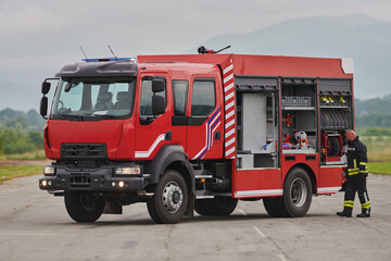 Fototapeta na wymiar A firefighter meticulously prepares a modern firetruck for a mission to evacuate and respond to dangerous situations, showcasing the utmost dedication to safety and readiness in the face of a fire