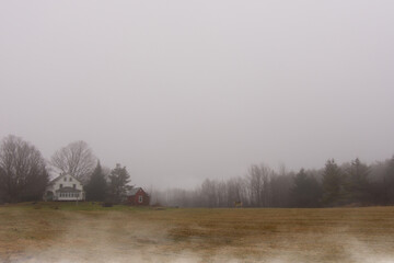 Landscape with farm of the Canadian countryside in Quebec on a foggy day