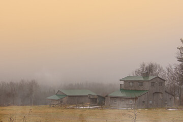 Landscape with barn of the Canadian countryside in Quebec on a foggy day