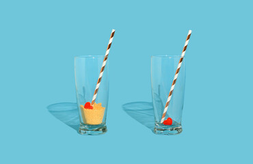 Minimal idea two glasses with crushed biscuit, juice straw and red gummies candy. Red heart in the...