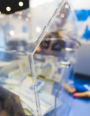 Process of prize drawings, extracting a winning numbers of lottery machine, raffle drum with a bingo balls, bingo machine and winning tickets on event with a host, hands on lottery machine