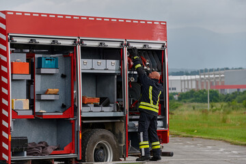A firefighter meticulously prepares a modern firetruck for a mission to evacuate and respond to...