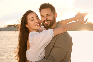 Portrait of happy couple near river on sunny day