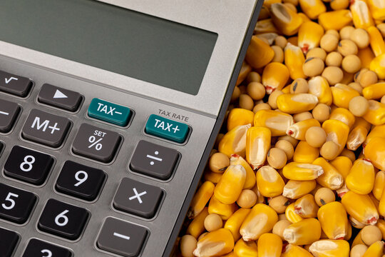 Tax calculator with corn and soybeans. Farm income, agriculture sales and property taxes concept
