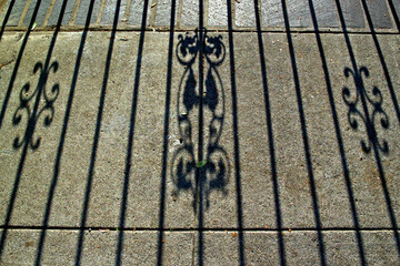 Shadow cast by gate with Victorian accents 