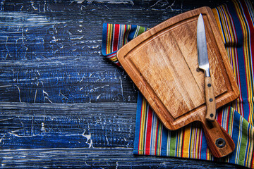 wooden cutting board on a dark blue background. Preparation of appliances and ingredients for home cooking.