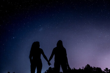 Starry night with two persons silhouette