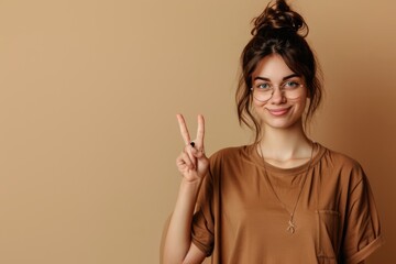 Photo of cheerful dreamy girl dressed brown shirt showing two fingers