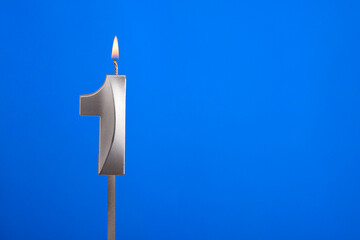 Birthday number 1 - Candle lit on blue background