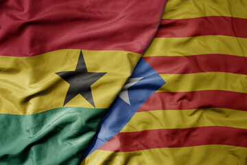 big waving national colorful flag of catalonia and national flag of ghana .