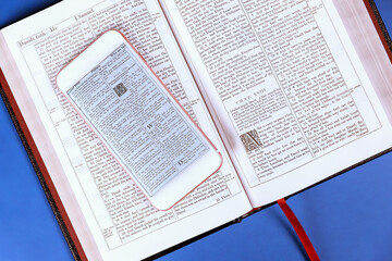 24 DECEMBER 2023 Washington DC USA. An open reading Bible, smartphone are placed on wooden table for study