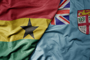 big waving national colorful flag of Fiji and national flag of ghana .