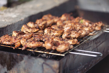 meat on barbecue grill at bbq party in summer garden. Food, people and family time concept. Grilled chicken breast on barbeque, cooking process .