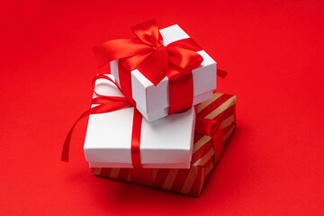 Close up pile of decorated present boxes isolated over bright colored red paper background