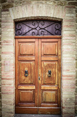 Old wooden door on a brick wall - 699350200