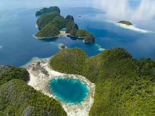 A blue hole is found amid the limestone seascape in Misool, Raja Ampat, Indonesia. These scenic...