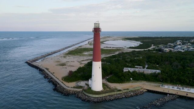 A 4K drone shot of the Barnegat Lighthouse, located on the northern tip of Long Beach Island in Ocean County, New Jersey, U.S.A. The camera rises and rotates left around the lighthouse.