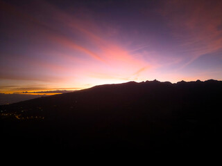 Fondo puesta de sol turquesa rodeado de montañas.