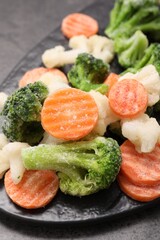 Mix of different frozen vegetables on grey table, closeup