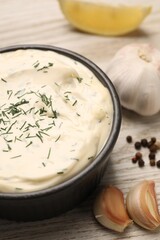 Tasty sauce with garlic, spices and dill on light wooden table, closeup