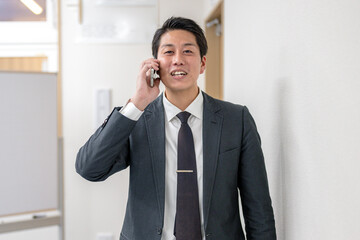 笑顔で携帯で話すビジネスマン