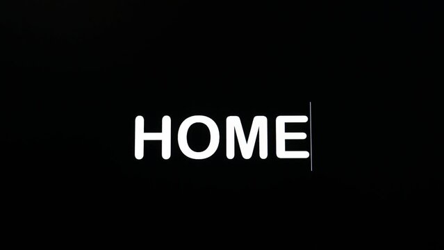 Detail of paragraph typing the word home on a dark background on screen
