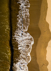 waves crashing on the beach seen from above