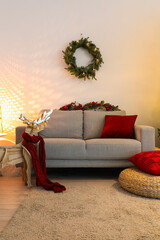 Interior of living room with Christmas wreath, sofa and reindeer