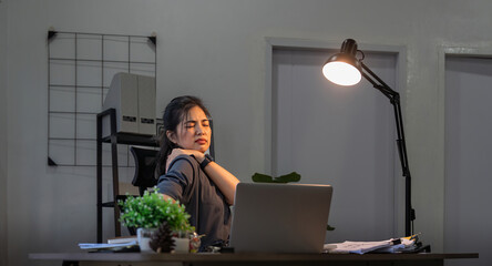 Asian business woman have a neck pain because using the laptop computer and working for a long time...