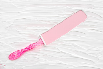 Safety razor with shaving foam on pink background