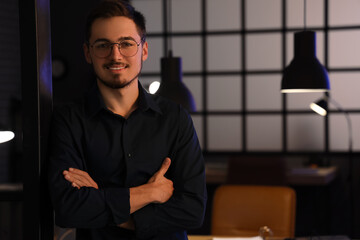 Handsome young man in office at night