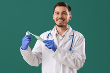 Handsome young man with electric brush and plastic tooth on green background. Dental care concept - obrazy, fototapety, plakaty