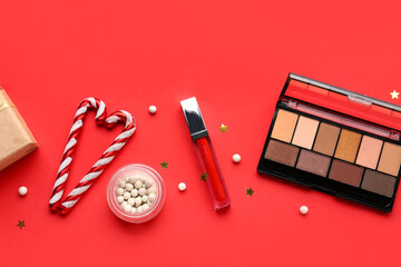 Christmas composition with different makeup products on red background