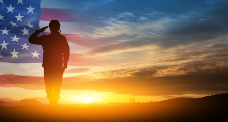 Silhouette of soldier saluting on background of sunset or sunrise and USA flag. Greeting card for...