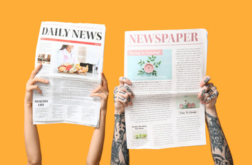 Female and male hands with newspapers on yellow background