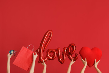 Women with credit cards, shopping bag, heart and word LOVE on red background. Valentine's Day...